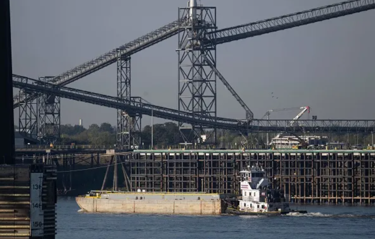 Image of barge in the lower Mississippi river going past exposed dock